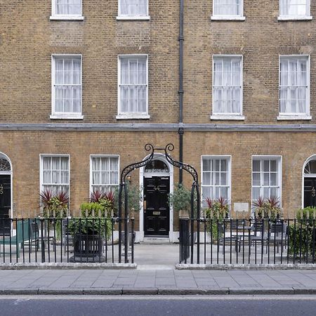 Montcalm Brewery Townhouse Londres Exterior foto The photo shows a row of three-story brick buildings, featuring a classic design with large windows and decorative ironwork. The buildings are painted in a muted yellow-brown color, typical of older urban architecture. In front of the buildings, ther