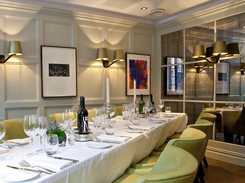 Montcalm Brewery Townhouse Londres Exterior foto The photo shows an elegant restaurant setting with a long dining table that is neatly set for a meal. The table is adorned with a white tablecloth, glassware, and silverware, indicating that it is prepared for a special gathering or event. 

Behind t